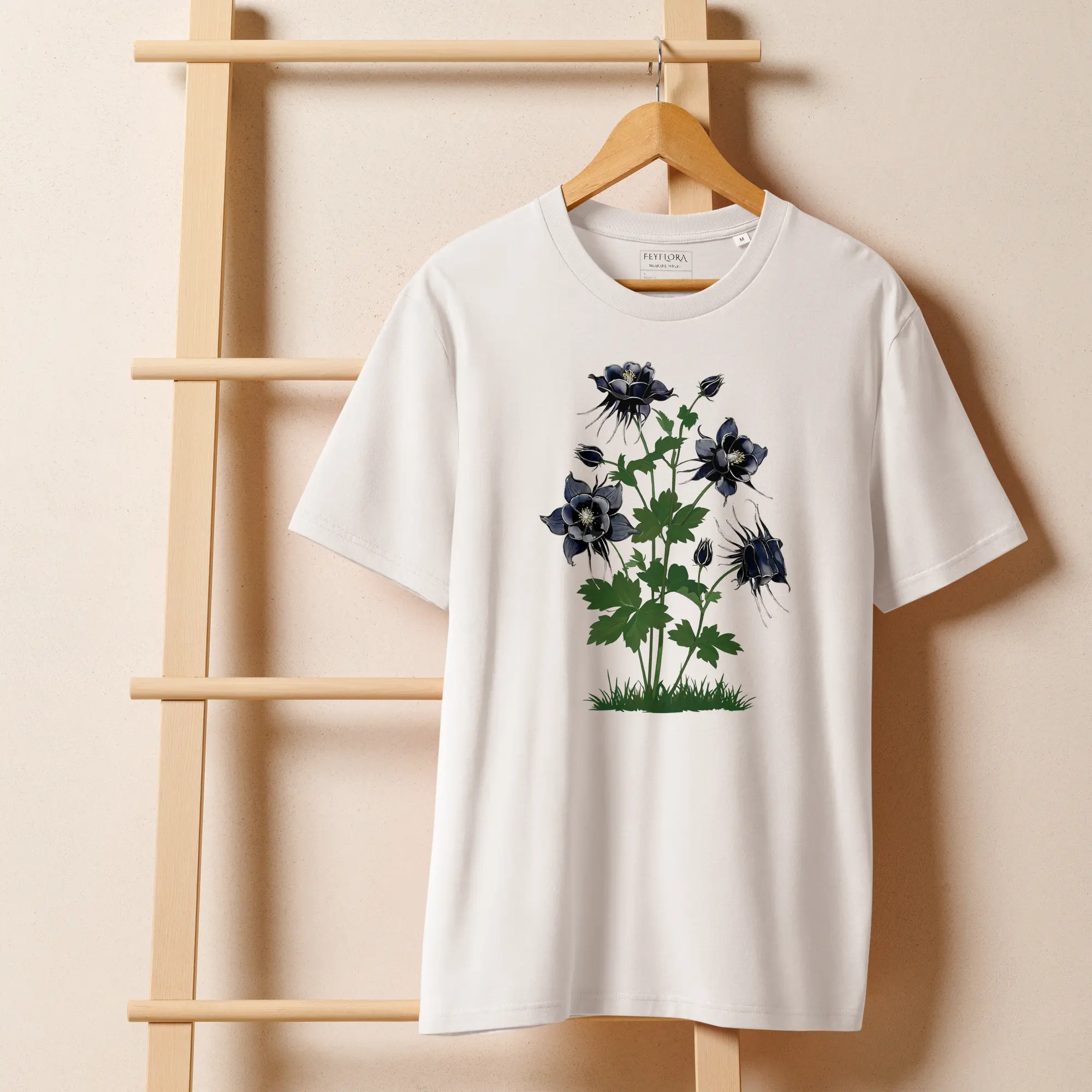 Midnight Columbine white t-shirt hanging on a wooden hanger — gothic botanical illustration in daylight